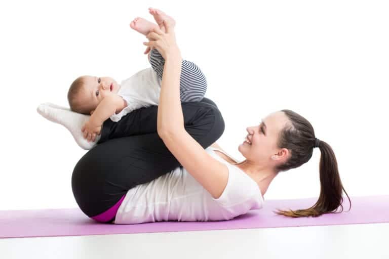 Mother doing yoga exercise with her baby